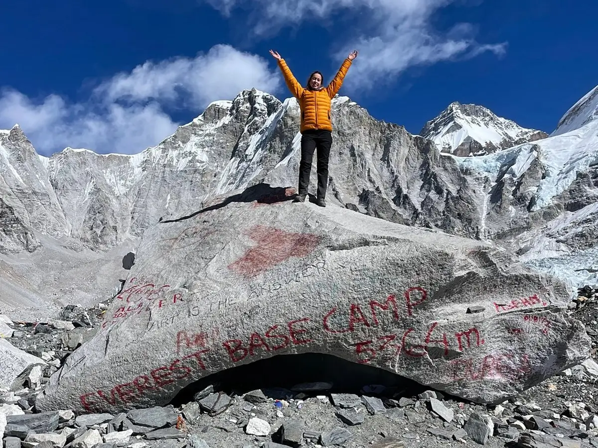 Trekker celebrating at Everest Base Camp during an EBC trek in Nepal