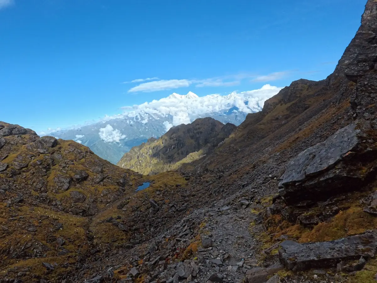 Rocky trail with distant snowy peaks on the return trek from Mera Peak