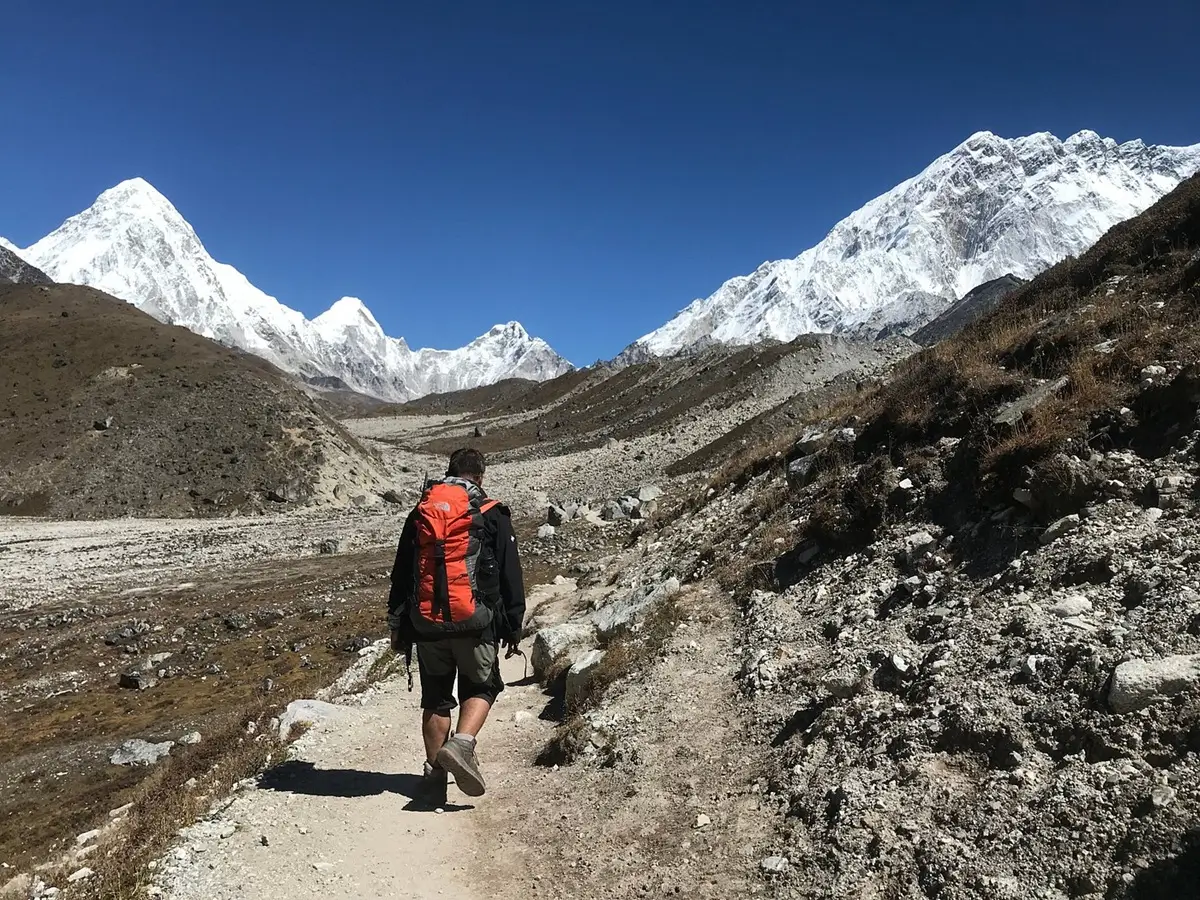 Trekker walking along a rocky trail on the approach to Mera Peak